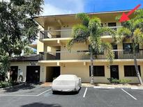Multi-story condo building featuring balconies, mature trees, and reserved parking spaces at 425 30Th W Ave # C308, Bradenton, FL 34205