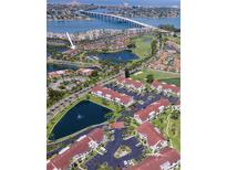Aerial view of waterfront condo community, showcasing lush landscaping, ponds, and a nearby bridge at 6100 Bahia Del Mar Cir # 102, St Petersburg, FL 33715