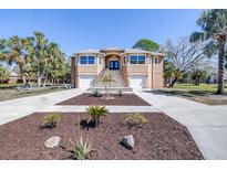 Stunning two-story home featuring a grand entrance, two garages, and beautiful landscaping at 733 Seminole Blvd, Tarpon Springs, FL 34689