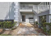 Charming condo exterior with gray siding, stone walkway, and well-maintained landscaping at 12041 Hoosier Ct # 104, Hudson, FL 34667