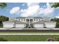Inviting townhome featuring light green siding, six garages, and a stylish facade at 12785 Jade Empress Loop # 201, Venice, FL 34293