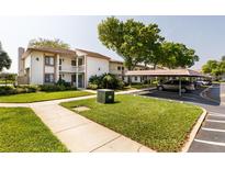 Well-maintained condo building with a carport and nicely landscaped lawn area at 142 Lakeview Way # 142, Oldsmar, FL 34677