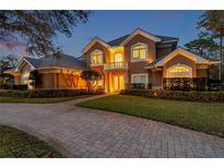 Elegant two-story home with a beautiful brick driveway and a charming front balcony at 2280 Mackenzie Ct, Clearwater, FL 33765