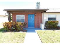 Charming single story home with a blue front door, red brick and manicured landscaping at 24862 Us Highway 19 N # 2801, Clearwater, FL 33763