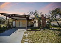 Charming single-story home featuring a carport, brick chimney and quaint front yard at 4002 W Gray St, Tampa, FL 33609