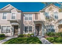 Inviting two-story townhome featuring a covered entryway, well-maintained lawn, and charming architectural details at 4535 Kennewick Pl, Riverview, FL 33578