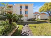Inviting condo exterior featuring manicured landscaping, street lamp, and a welcoming walkway at 9960 5Th St. N. # 304, St Petersburg, FL 33702