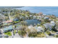 Stunning aerial view of waterfront homes, docks, and boats on a sunny day near a large bay at 120 Carlyle Cir, Palm Harbor, FL 34683