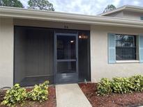 Charming home entrance with a screened-in porch, blue shutters, and a well-maintained yard at 2131 Ridge S Rd # 86, Largo, FL 33778