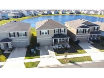 A beautiful exterior view of the house with a lake nearby at 9119 Forge Breeze Loop, Wesley Chapel, FL 33545