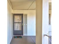 View of the front door to this residence with a decorative welcome mat and neutral facade at 19029 Us Highway 19 N # 1-22, Clearwater, FL 33764