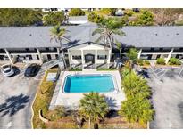 An aerial view of a building with a pool, parking, palm trees and landscaped grounds in a convenient location at 2 N Fernwood Ave # 8, Clearwater, FL 33765