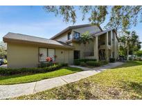 Inviting exterior showcasing a two-story building with lush landscaping and a well-maintained lawn on a sunny day at 3050 Landmark Blvd # 1008, Palm Harbor, FL 34684