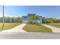 Charming two-story home with a well-manicured lawn and double driveways at 4010 Jewfish Dr, Hernando Beach, FL 34607
