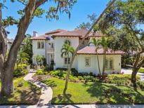 Stunning two-story home with lush landscaping, red tile roof, and a brick walkway leading to the front entrance at 808 Idlewood Ave, Tampa, FL 33609