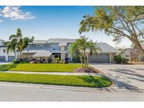 Charming two-story home with lush landscaping, mature trees, and a well-manicured lawn at 9011 Baywood Park Dr, Seminole, FL 33777