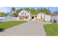 Charming two-story home with manicured lawn, white picket fence, and large driveway at 1751 Massachusetts Ne Ave, St Petersburg, FL 33703