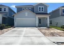 Charming two-story home featuring a two-car garage and neatly paved driveway at 28740 Jujube Rd, Wesley Chapel, FL 33543