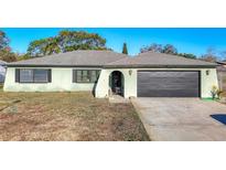 Charming single-story home with attached garage and well-maintained lawn at 8709 Wabash Ln, Port Richey, FL 34668