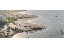 Stunning aerial view of the sandy beach, clear water, and beachfront condos at 1100 Pinellas Bayway S # H2, Tierra Verde, FL 33715