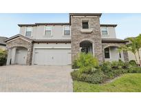 Stunning two-story home featuring stone accents, a two-car garage, and beautiful landscaping at 13176 Twin Bridges Dr, Riverview, FL 33579