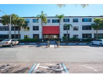 Exterior view of condo building with palm trees and parking, featuring a covered entrance and well-maintained landscaping at 2587 Countryside Blvd # 6103, Clearwater, FL 33761