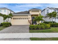 Charming single-Gathering home with manicured landscaping, paved driveway, and attached two-car garage at 407 Sandsend Ct, Apollo Beach, FL 33572