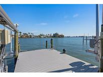 Waterfront dock with boat lift and open water views on a sunny day at 5451 Oakhurst Dr, Seminole, FL 33772