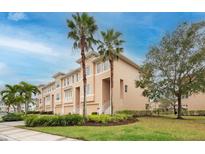 Townhome exterior showcasing front entrances, garages, palm trees and manicured landscaping at 7100 Islamorada Cir, Seminole, FL 33777