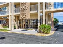 Exterior of the building entrance showcasing manicured landscaping and the building's architectural details at 113 Island Way # 241, Clearwater Beach, FL 33767