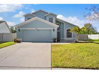 Charming two-story home features an attached two-car garage, well-manicured lawn, and tasteful landscaping at 13411 Beechberry Dr, Riverview, FL 33579