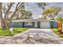 Charming single-story home with a well-maintained lawn and a concrete driveway leading to an attached garage at 1466 Laconia W Dr, Clearwater, FL 33764