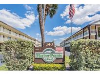 Inviting Harbor Pointe West community sign with lush landscaping and bright blue sky backdrop on a sunny day at 340 Causeway Blvd # 108, Dunedin, FL 34698