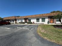 Well-maintained condo building featuring convenient parking and tidy landscaping under a bright blue sky at 6165 Chesham Dr # 2, New Port Richey, FL 34653