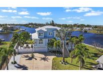 Beautiful waterfront home featuring lush landscaping, white picket fence, and a private dock at 829 Blue Heron Blvd, Ruskin, FL 33570
