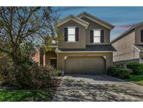 Inviting two-story home featuring a two-car garage and manicured landscaping at 10222 Newminster Loop, Ruskin, FL 33573