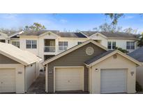 A multi-story townhouse complex with attached garages and a landscaped walkway under a blue sky at 11320 Harbor Way # 1725, Largo, FL 33774