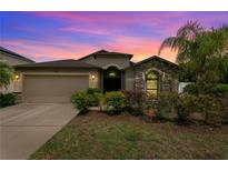 Charming single Gathering home featuring a stone facade, mature landscaping and a two car garage at 1426 Main St, Valrico, FL 33594