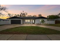 Charming single-story home featuring a well-manicured lawn, fresh exterior paint, and a dark two-car garage at 1621 S Keene Rd, Clearwater, FL 33756