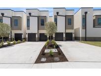 Modern townhomes showcase a sleek design and private garages with landscaping at 216 N Hesperides St, Tampa, FL 33609