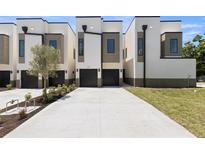 Modern townhomes featuring neutral colors, individual garages, and concrete driveways on a sunny day at 222 N Hesperides St, Tampa, FL 33609