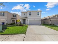 Charming two-story home with a well-maintained lawn, landscaped yard, and a spacious two-car garage at 31386 Penny Surf Loop, Wesley Chapel, FL 33545