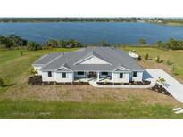 Aerial view of a beautiful home with a large yard, close to a serene lake at 3319 Gulf City Rd, Ruskin, FL 33570