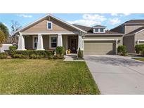 Charming single-Gathering home with well-manicured lawn, columns, a two-car garage and fresh landscaping at 4919 Lakeshore Oaks Ct, Tampa, FL 33624