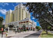 Beautiful yellow 14 story building with red awnings and sidewalks at 628 Cleveland St # 1507, Clearwater, FL 33755