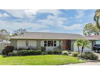 Charming single-story home with a well-maintained lawn, mature landscaping, and a welcoming front entrance at 7650 Dover Ct, St Petersburg, FL 33709
