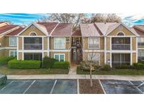 Inviting two-story condo featuring a well-maintained lawn, screened porches, and designated parking spaces at 9481 Highland Oak Dr # 1410, Tampa, FL 33647