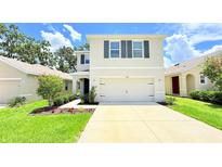 Charming two-story home with neutral stucco, dark shutters, two car garage, and well-manicured landscaping at 10908 Carlton Fields Dr, Riverview, FL 33579