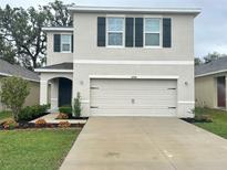 Charming two-story home featuring a two-car garage and nicely landscaped front yard with flower beds at 10908 Carlton Fields Dr, Riverview, FL 33579