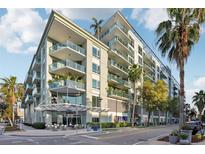 Modern condo building with balconies, palm trees, and street-level shops at 111 N 12Th St # 1819, Tampa, FL 33602